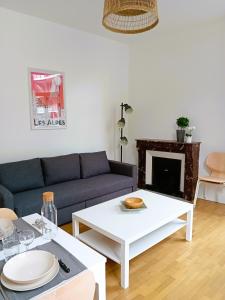 a living room with a couch and a table at 102 - Appart rénové avec grand salon et 1 chambre - Tram et Clinique Mutualiste à 1 min in Grenoble