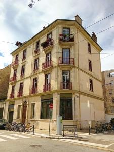 un edificio en la esquina de una calle en Appart rénové avec grand salon et 1 chambre - Tram et Clinique Mutualiste à 1 min en Grenoble