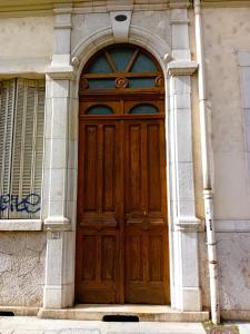 una puerta de madera en el lateral de un edificio en Appart rénové avec grand salon et 1 chambre - Tram et Clinique Mutualiste à 1 min, en Grenoble