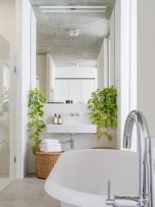 a bathroom with a sink and two potted plants at Carlotta Apartments in Berlin