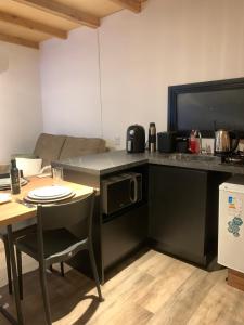 a kitchen with a couch and a table with a microwave at Tiny House no Olival in Pelotas