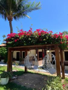 a gazebo with pink flowers and pink at Pousada Capitão Thomaz in Jericoacoara