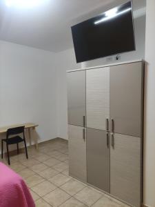 um quarto com uma cómoda e uma televisão de ecrã plano por cima em Caracciolo B&B em Fiano Romano