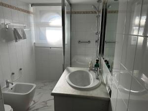 biała łazienka z umywalką i prysznicem w obiekcie PARIOLI LUXURY SUITE III w Rzymie