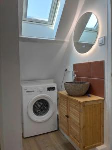 Un baño con lavadora y lavabo. en Appartement - Vendôme, en Vendôme