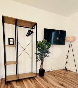 Cette chambre dispose d'une télévision et d'une plante. dans l'établissement Wohlfühl-Apartment Mareiki*Balkon*Stellplatz*WIFI*, à Erfurt