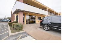 a black van parked in front of a store at Southern Comfort Hotel in Tulsa