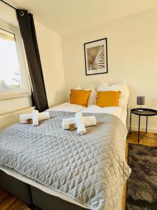 - une chambre avec un grand lit et des oreillers orange dans l'établissement Wohlfühl-Apartment Mareiki*Balkon*Stellplatz*WIFI*, à Erfurt