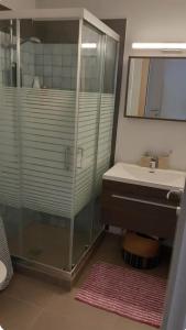 y baño con ducha acristalada y lavamanos. en La Casa Del Sol Villa en Aegenitissa