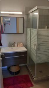 a bathroom with a sink and a glass shower at La Casa Del Sol Villa in Aegenitissa