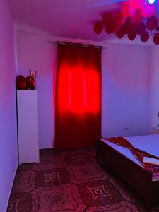 a bedroom with a red curtain and a bed at Pensão Simão & Júlia in Órgãos