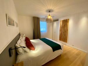 a bedroom with a large white bed with red pillows at La villa du golf - chambre d hôtes in Gujan-Mestras +21 photos
