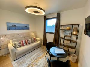 a living room with a couch and a table at La villa du golf - chambre d hôtes in Gujan-Mestras