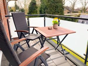 a patio table and chairs on a balcony at PEARLs - Stilvolle Neubauwohnung am Niederrhein in Elten