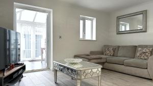 a living room with a couch and a table at Home Sweet Home (Townhouse) in Manchester