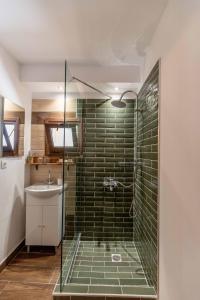 a bathroom with a glass shower with a sink at Mascot Memories in Rhodes Town