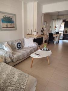 - un salon avec un canapé et une table dans l'établissement Sophie's Cozy House, à Patras