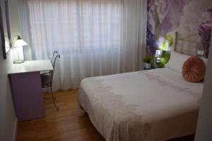 a bedroom with a bed and a desk and a window at Alojamientos Villarias Murcia in Murcia