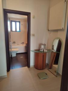 La salle de bains est pourvue d'un lavabo et d'une table. dans l'établissement Sophie's Cozy House, à Patras