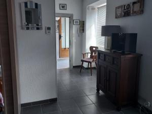 a living room with a television and a chair at Studio côté jardin in Ingersheim