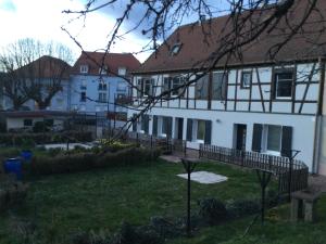 una grande casa bianca con un cortile davanti di Studio côté jardin a Ingersheim