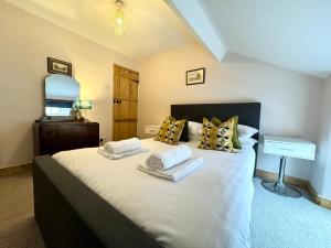 a bedroom with a bed with two towels on it at The Old Locksmith Cottage, Ulverston - Lake District in Ulverston
