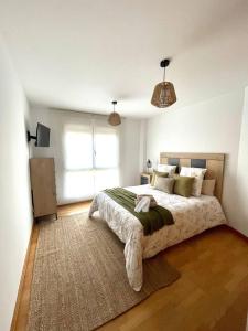 een slaapkamer met een groot bed en een groot raam bij Apartamento en palmeira - Colores del Barbanza Naranja in Ribeira