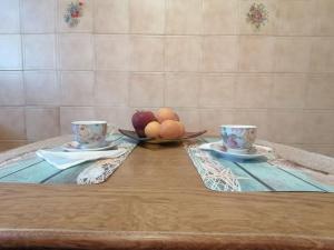 a table with two cups and a bowl of fruit at katerina's house in Khónai
