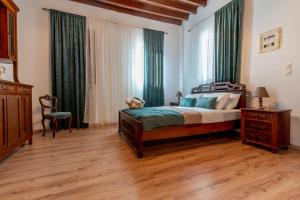 a bedroom with a large bed with green curtains at Mascot Memories in Rhodes Town