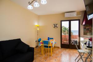 uma sala de estar com um sofá e uma mesa com cadeiras em Mediterranean Terraces - Sandy Beach em Villajoyosa
