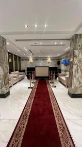 メッカにあるفندق الروابط نفحات الحرم سابقاの赤いカーペットとステージが施された広い客室です。