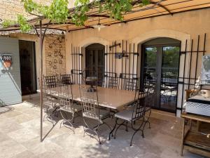 a wooden table and chairs in a patio at Appartement Murs, 8 pièces, 10 personnes - FR-1-767-17 in Murs