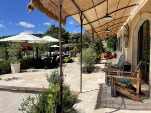 an outdoor patio with umbrellas and chairs and tables at Appartement Murs, 8 pièces, 10 personnes - FR-1-767-17 in Murs