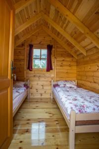 a bedroom with two beds in a log cabin at Maple bungalows in Žabljak