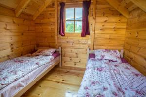 a bedroom with two beds in a log cabin at Maple bungalows in Žabljak