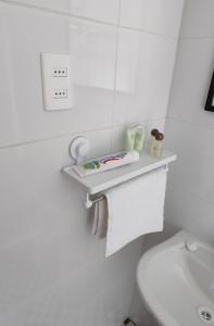 a bathroom with a toilet and a shelf on the wall at Tiny House - Oasis de tranquilidad, belleza y seguridad in Los Barriales