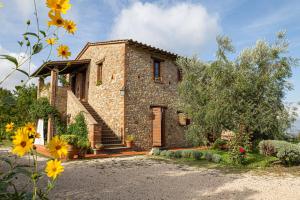 a stone house with a door and flowers at Agriturismo Cornieto in Monteleone dʼOrvieto