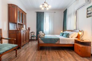 a bedroom with a bed and a chair in it at Mascot Memories in Rhodes Town