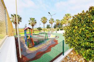 a playground with a slide in a park with palm trees at EXPOHOLIDAYS - Vistas al mar playa ensenada in Almerimar