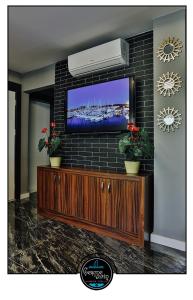 a living room with a television on a brick wall at çesme marin butik otel in İzmir