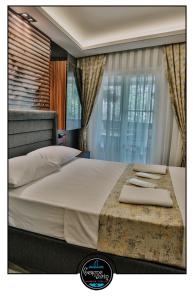 a bedroom with a large bed with white sheets and pillows at çesme marin butik otel in İzmir