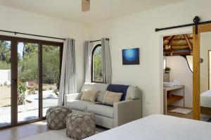 a bedroom with a bed and a couch and a window at Mantra Baja, Boutique Hotel in Los Barriles