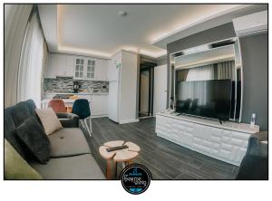 a living room with a couch and a flat screen tv at çesme marin butik otel in İzmir