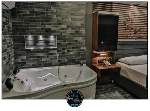 a bathroom with a bath tub next to a bed at çesme marin butik otel in İzmir