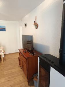 a living room with a tv on a wooden dresser at Ha-Py Friends in Campan