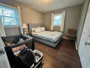 ein kleines Schlafzimmer mit einem Bett und einem Babybett in der Unterkunft Foundation Paradise in Fayetteville