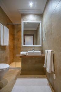 bagno con lavandino, servizi igienici e specchio di Al Karob Yoga Boutique Hotel a Guia