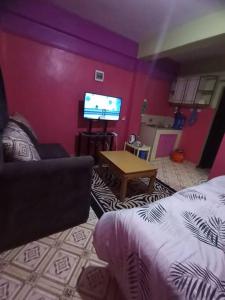 un soggiorno con divano e TV a schermo piatto di Wamusa Homes at Chaka a Kiganjo