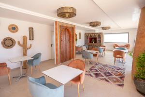 una habitación con mesas, sillas y un cactus en Al Karob Yoga Boutique Hotel en Guia
