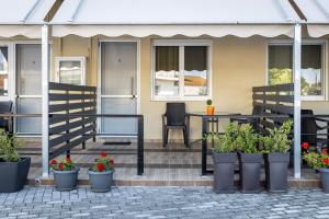 a patio with a table and chairs and potted plants at Sunny Studios 2 in Mángana